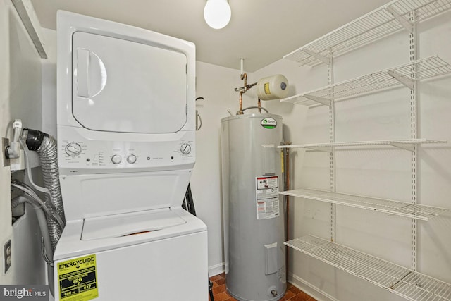 laundry room featuring brick floor, stacked washer and dryer, laundry area, and water heater