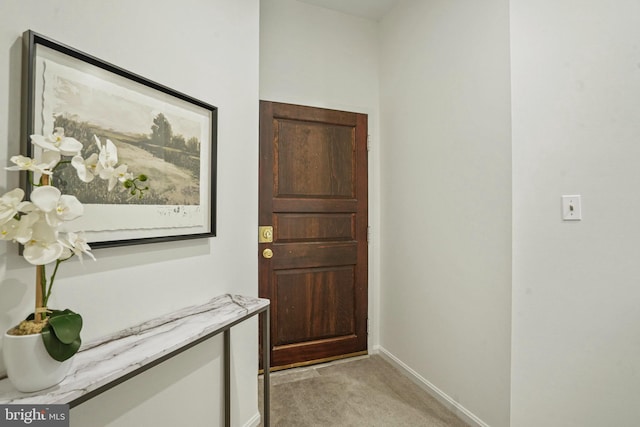 doorway with light carpet and baseboards