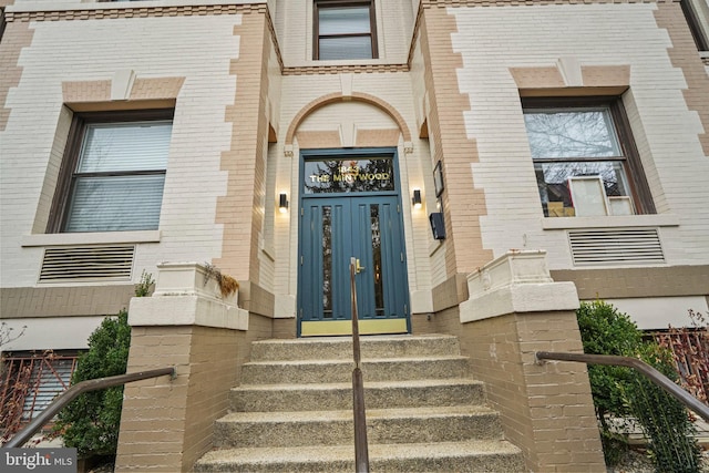 doorway to property with brick siding