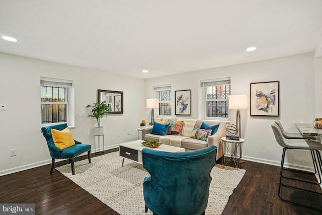 living area with recessed lighting, wood finished floors, baseboards, and a healthy amount of sunlight