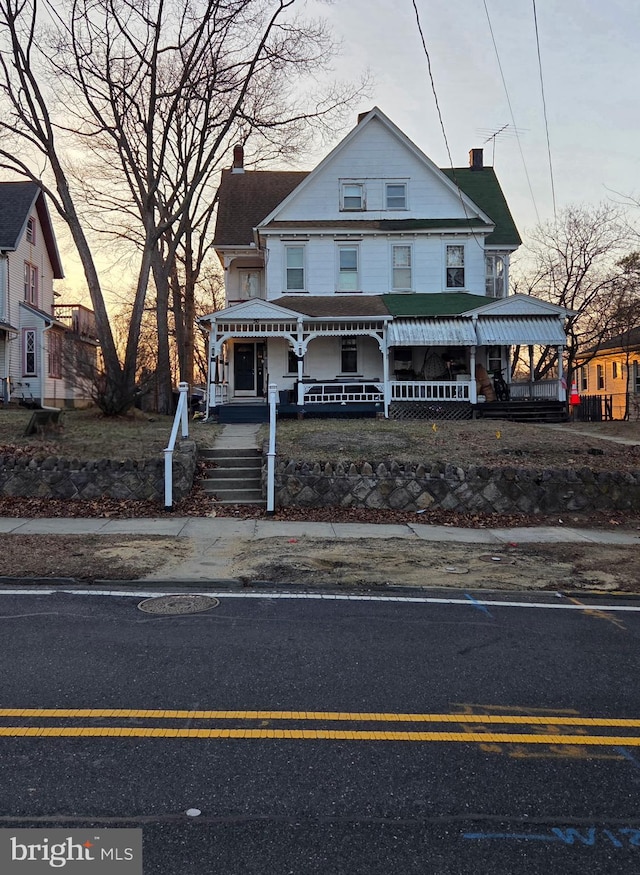 view of front of home featuring a porch and a chimney