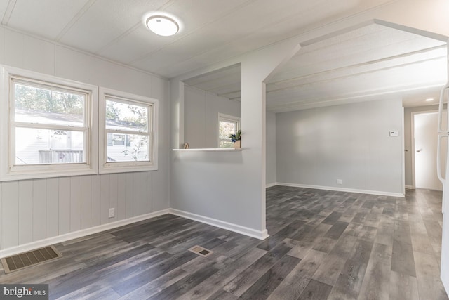 spare room with dark wood finished floors, baseboards, and visible vents