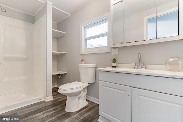 full bath featuring toilet, wood finished floors, a shower stall, baseboards, and vanity