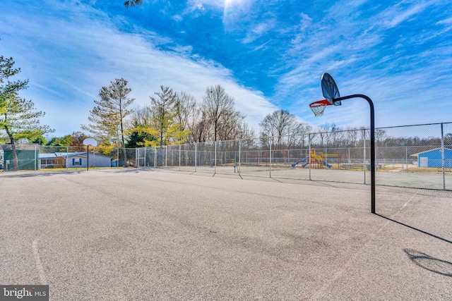 view of basketball court with community basketball court, fence, and playground community