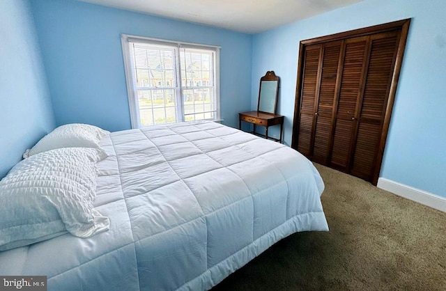 carpeted bedroom featuring a closet and baseboards