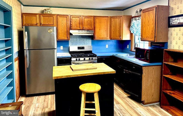 kitchen featuring open shelves, a sink, butcher block countertops, under cabinet range hood, and appliances with stainless steel finishes