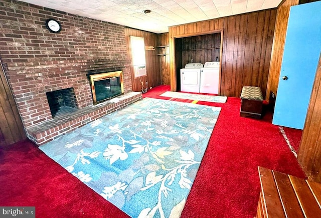 interior space with carpet flooring, washer and dryer, a brick fireplace, and wooden walls