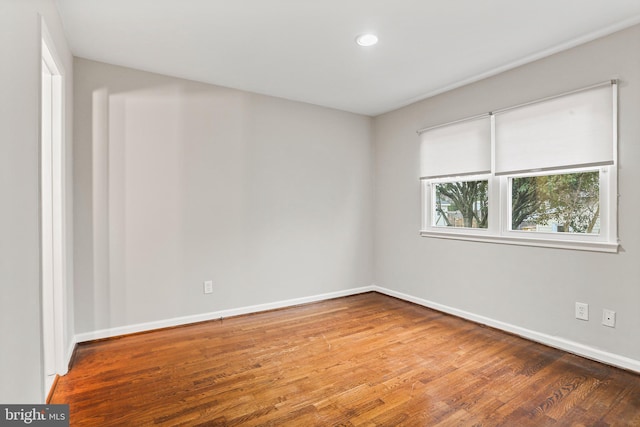 empty room featuring recessed lighting, baseboards, and wood finished floors