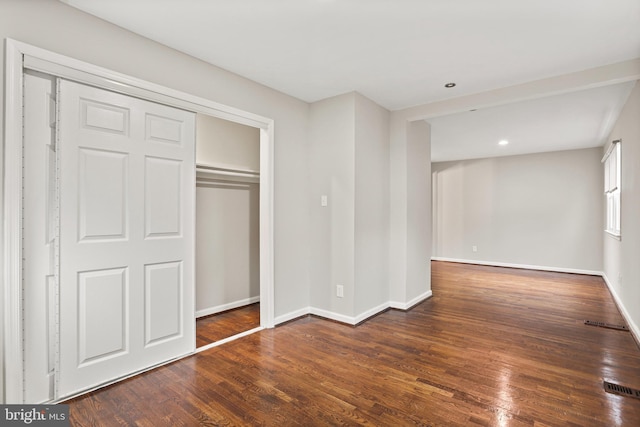 unfurnished bedroom with visible vents, wood finished floors, recessed lighting, a closet, and baseboards