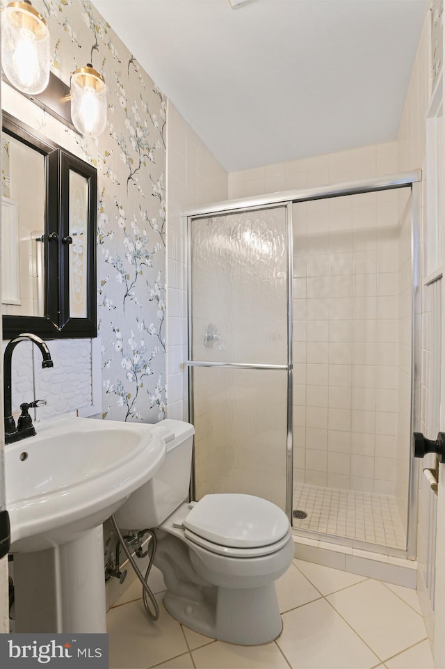 bathroom with tile patterned floors, a stall shower, and wallpapered walls