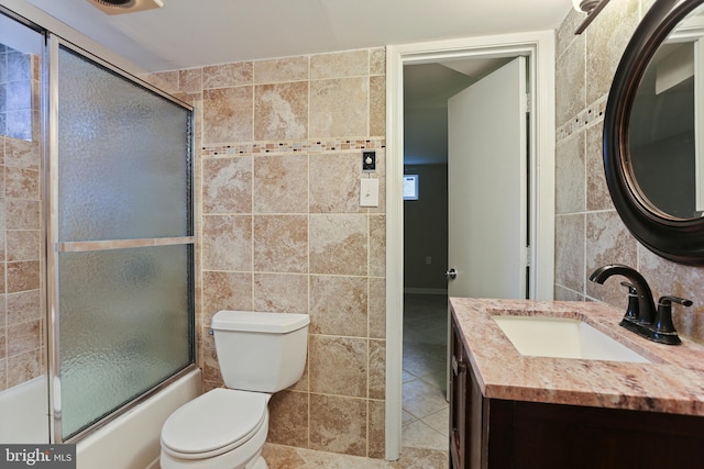 full bathroom with tile patterned flooring, tile walls, toilet, and enclosed tub / shower combo