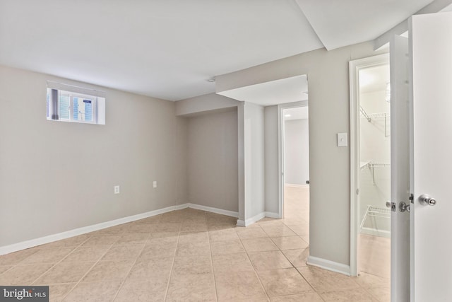 below grade area with light tile patterned floors and baseboards