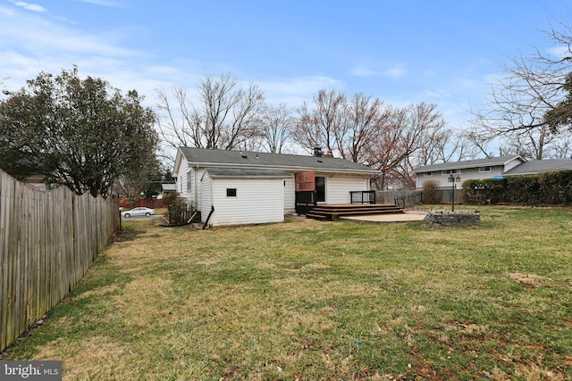 rear view of house featuring a yard, a wooden deck, and a fenced backyard