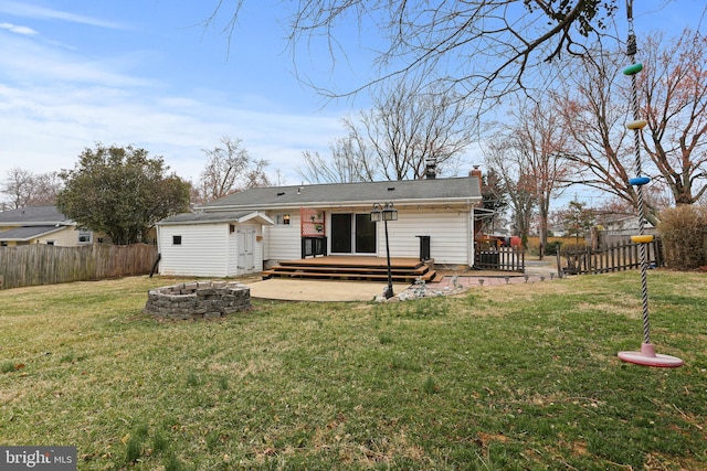 back of house with an outdoor fire pit, a chimney, a fenced backyard, a deck, and an outbuilding