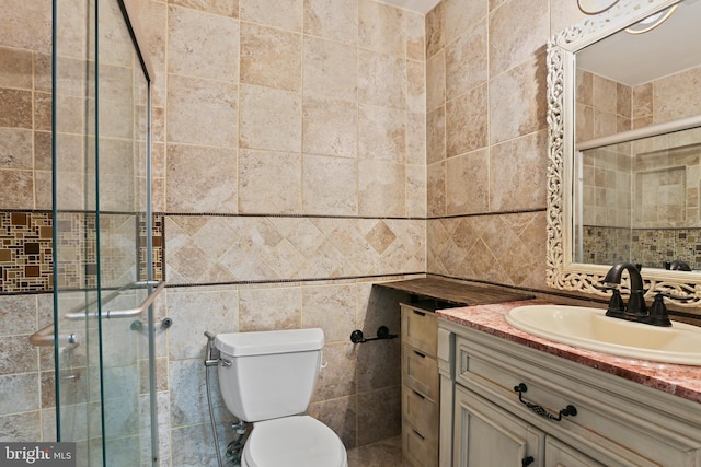 full bath with vanity, tile walls, toilet, and a stall shower