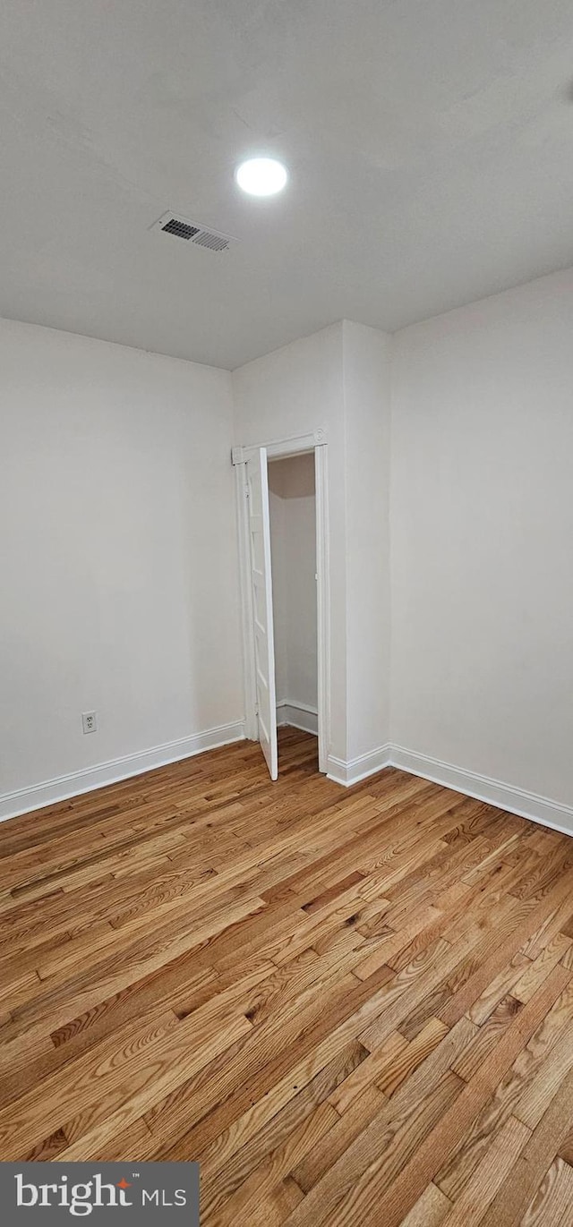 empty room featuring visible vents, baseboards, and light wood-style floors