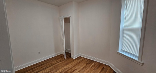 spare room featuring dark wood finished floors and baseboards