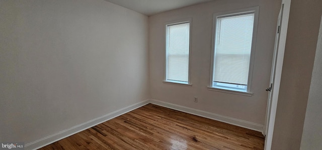 unfurnished room featuring dark wood-style floors and baseboards