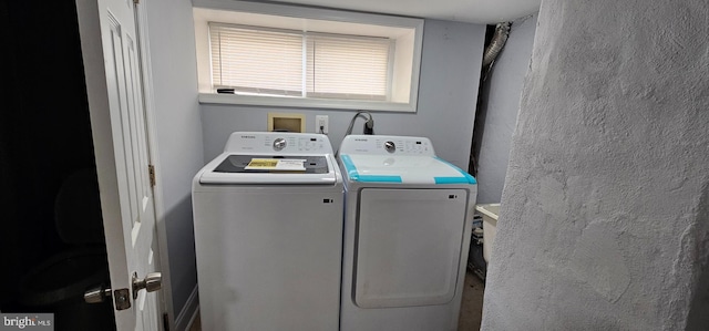 laundry room featuring laundry area, washing machine and dryer, and a textured wall