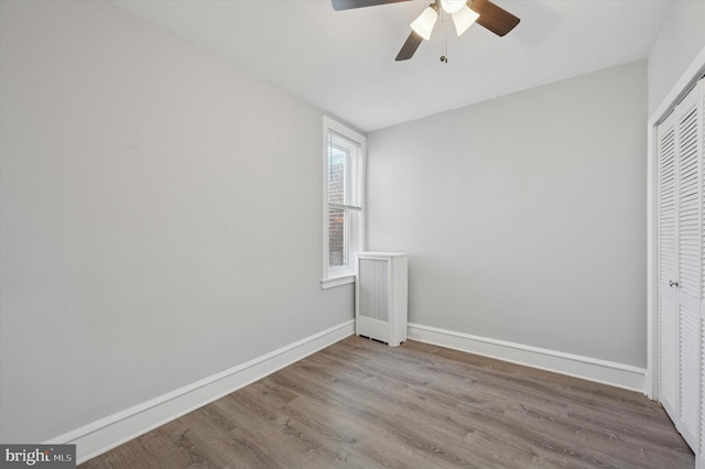 unfurnished bedroom with wood finished floors, baseboards, a closet, and ceiling fan