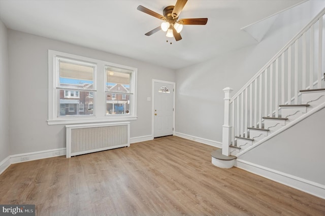 foyer featuring stairs, radiator, wood finished floors, and baseboards