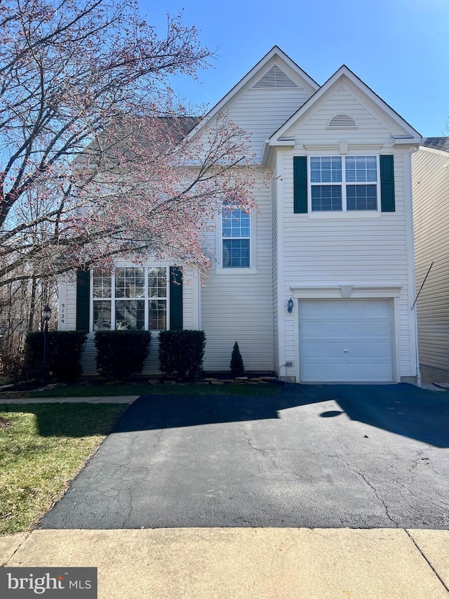 traditional home with aphalt driveway and an attached garage