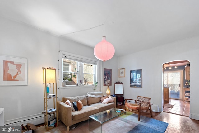 living area featuring a baseboard heating unit, wood finished floors, and arched walkways