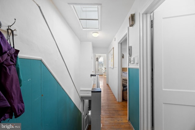 corridor featuring attic access and wood finished floors