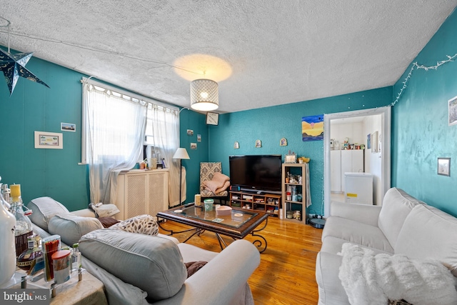 living area with a textured ceiling and wood finished floors