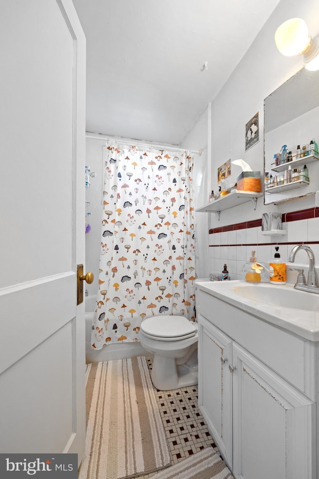 full bath with tile patterned flooring, tile walls, toilet, shower / tub combo, and vanity