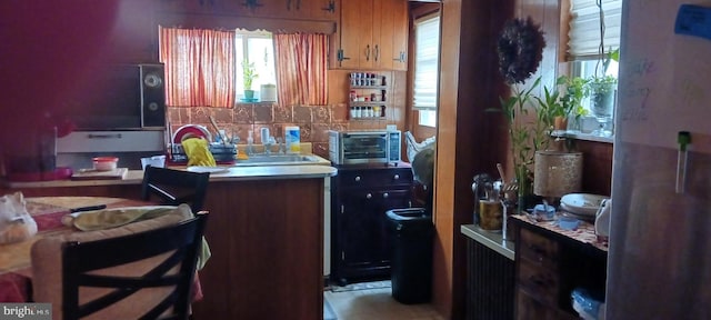 kitchen featuring a toaster, backsplash, and a sink