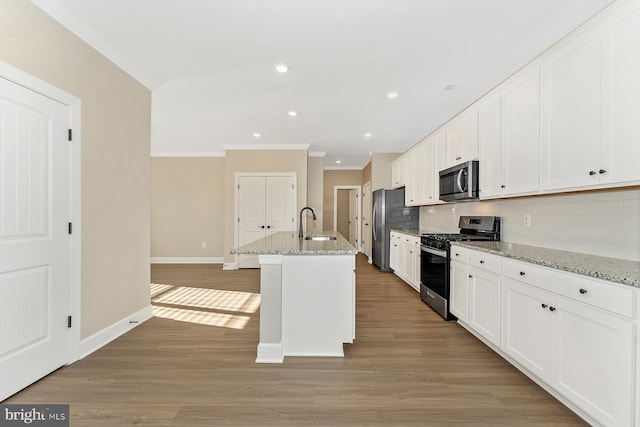 kitchen with stainless steel appliances, light wood finished floors, white cabinets, and ornamental molding