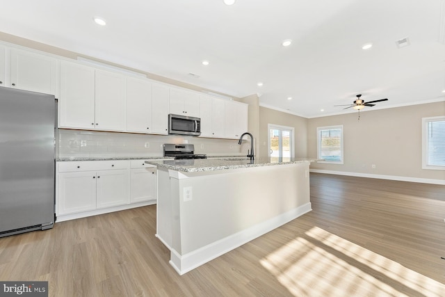 kitchen featuring tasteful backsplash, visible vents, crown molding, appliances with stainless steel finishes, and a sink