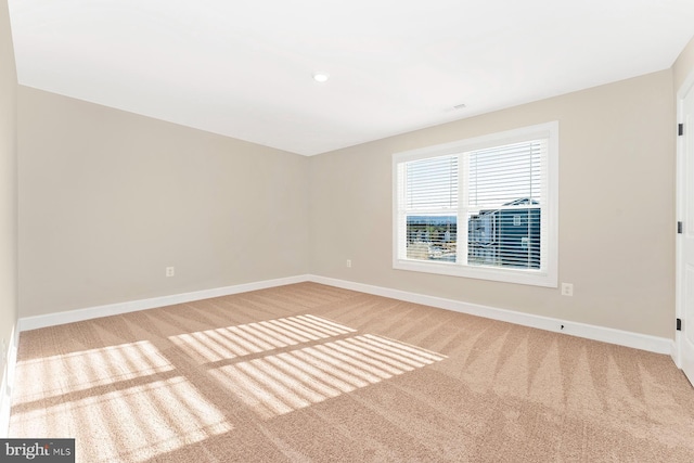 carpeted empty room with baseboards