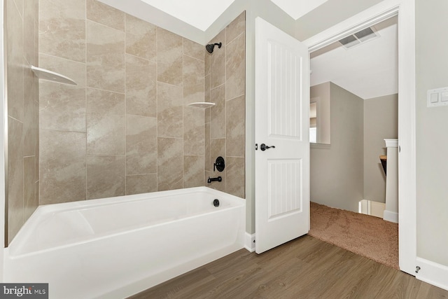 bathroom featuring tub / shower combination, wood finished floors, and visible vents