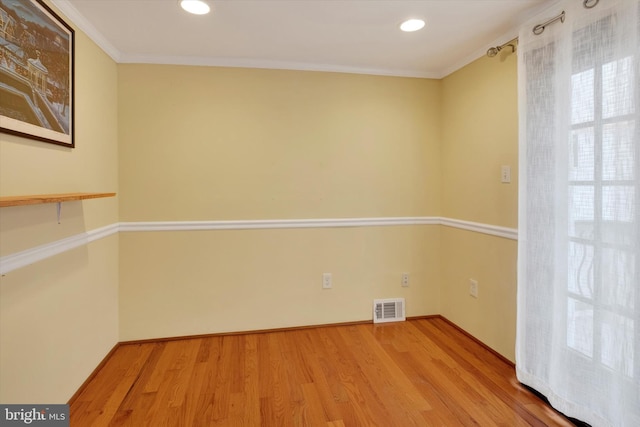 unfurnished room featuring visible vents, crown molding, baseboards, recessed lighting, and wood finished floors