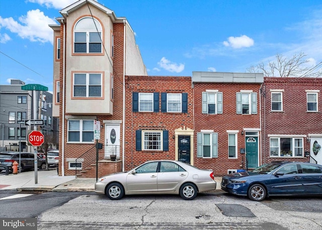 townhome / multi-family property with brick siding and stucco siding