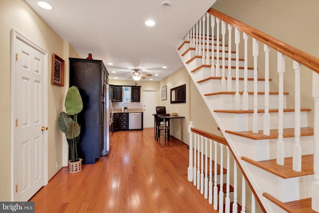 hallway with recessed lighting, stairs, and light wood-style floors