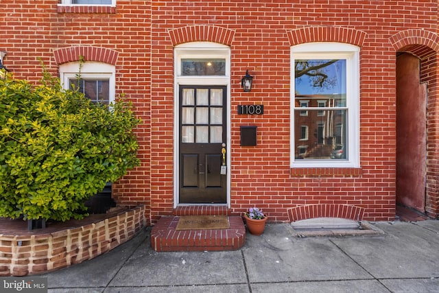 entrance to property featuring brick siding