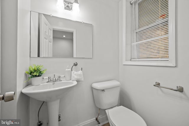 bathroom with toilet and baseboards