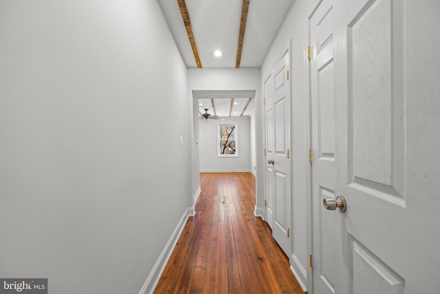 corridor featuring baseboards and hardwood / wood-style floors