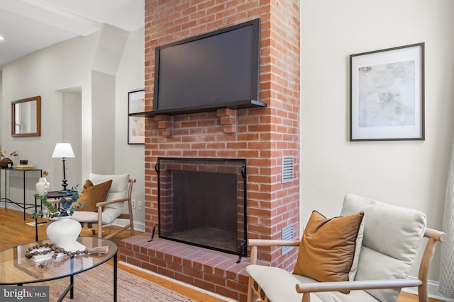 living area with a fireplace, wood finished floors, and baseboards