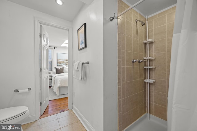 full bathroom featuring baseboards, ensuite bath, a tile shower, tile patterned flooring, and toilet