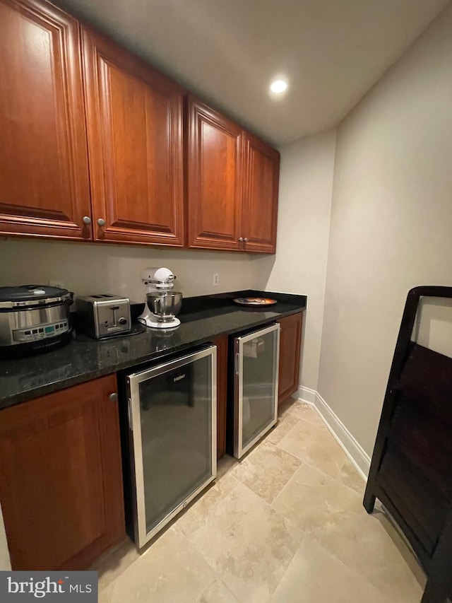 kitchen featuring recessed lighting, baseboards, brown cabinets, and beverage cooler