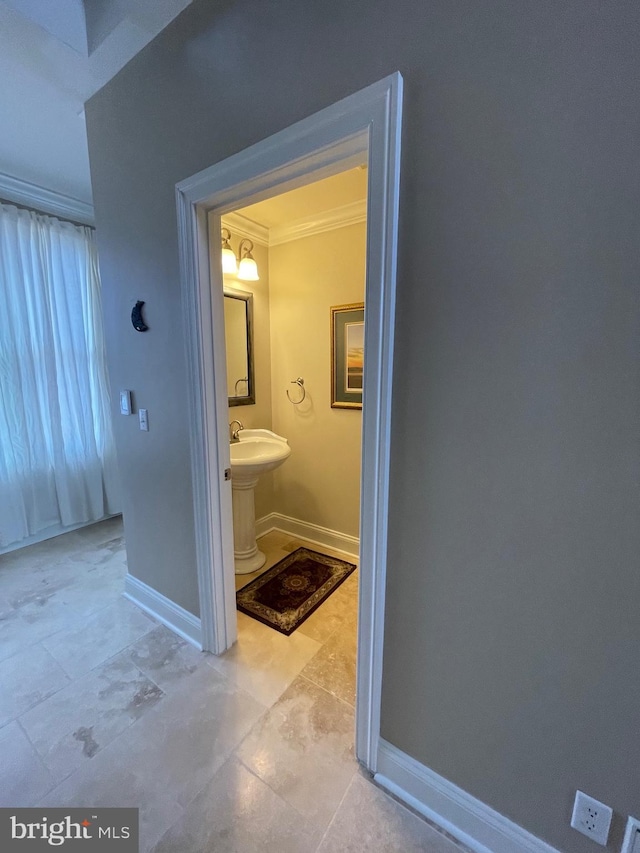 bathroom featuring crown molding and baseboards