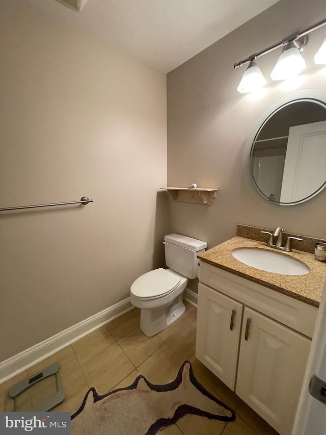 bathroom with tile patterned flooring, toilet, vanity, and baseboards