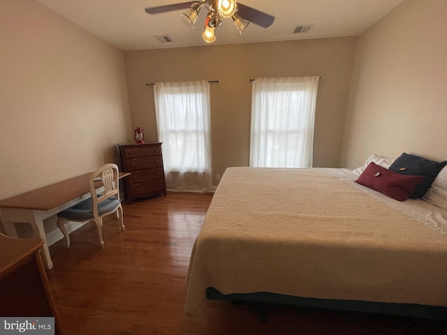 bedroom featuring visible vents, wood finished floors, and a ceiling fan