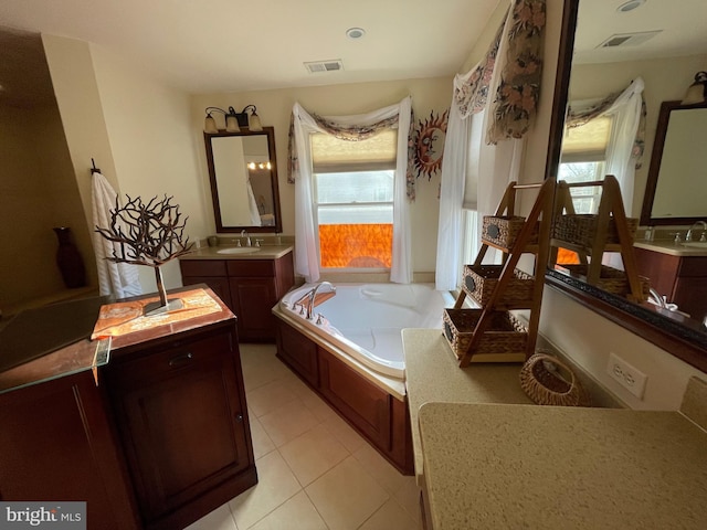 full bath with tile patterned flooring, visible vents, a garden tub, and a sink