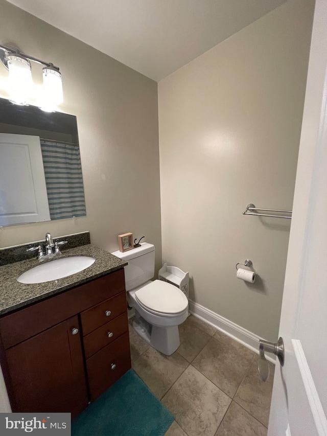 full bathroom with tile patterned flooring, toilet, vanity, and baseboards