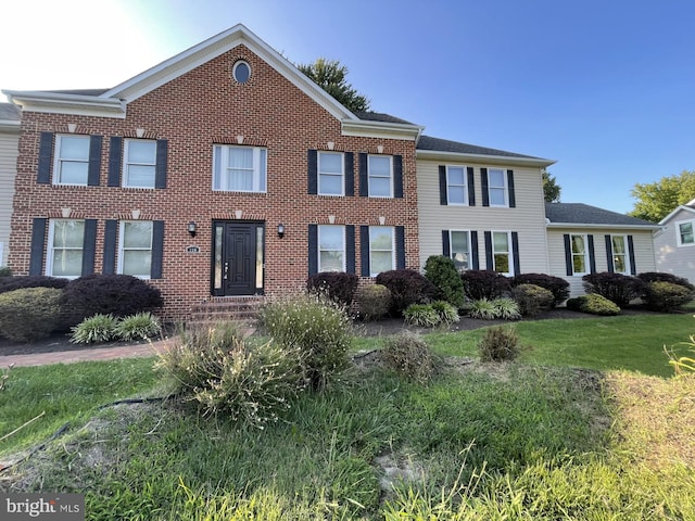 view of front facade featuring a front yard and brick siding